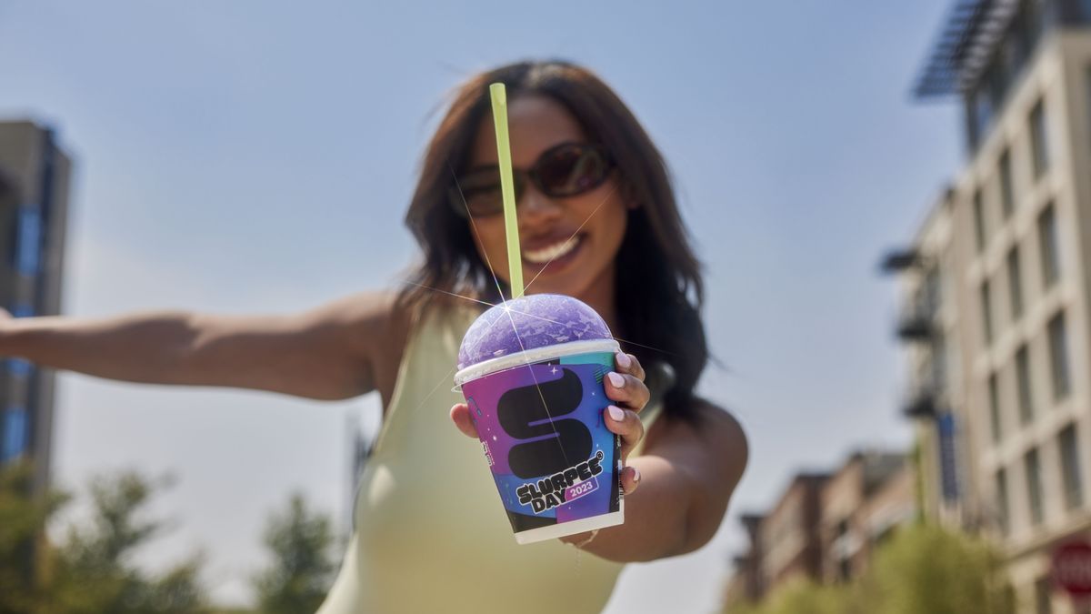 A photo of a person holding a Slurpee.