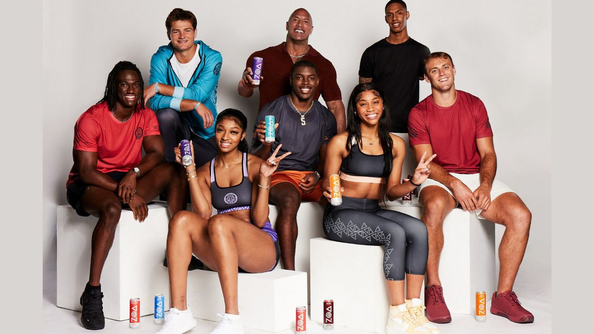 A group of athletes sit against a white background surrounded by Zoa Energy drinks.